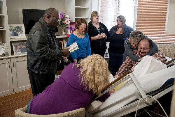 Photo of emotional and spiritual supporters helping a patient and their family.
