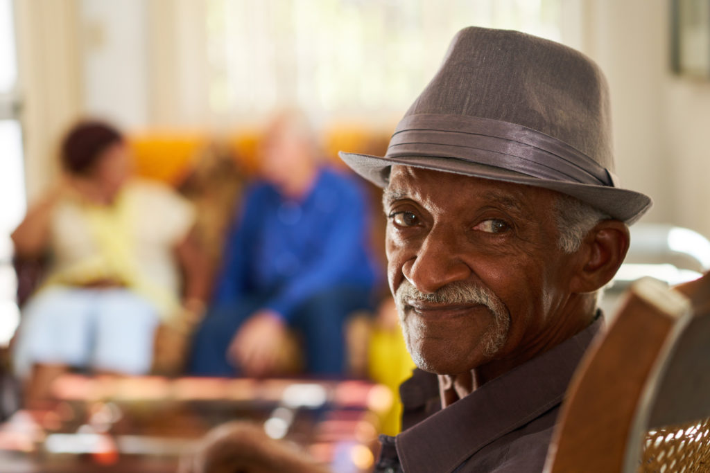 Photo of a man sitting in a chair smiling.